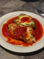Stuffed bell peppers with tomato sauce on a white plate